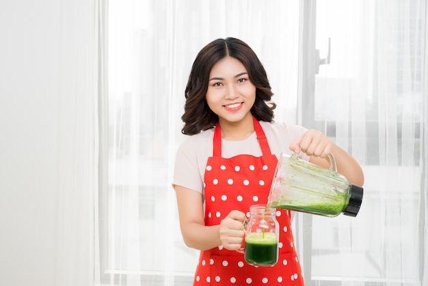 Foto la mujer va verde batido saludable en blander para el desayuno