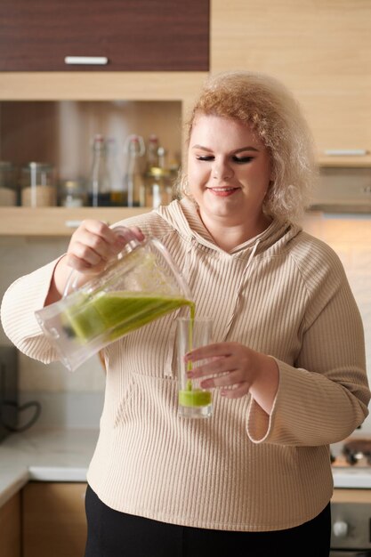 Mujer vertiendo batido en vaso