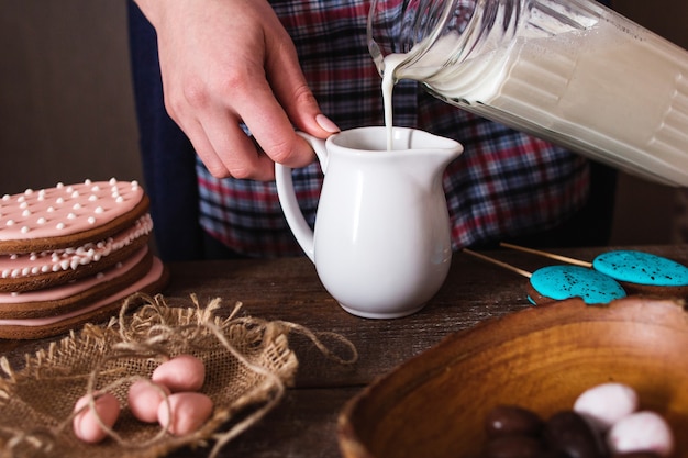 Mujer vertiendo leche en tarro pequeño