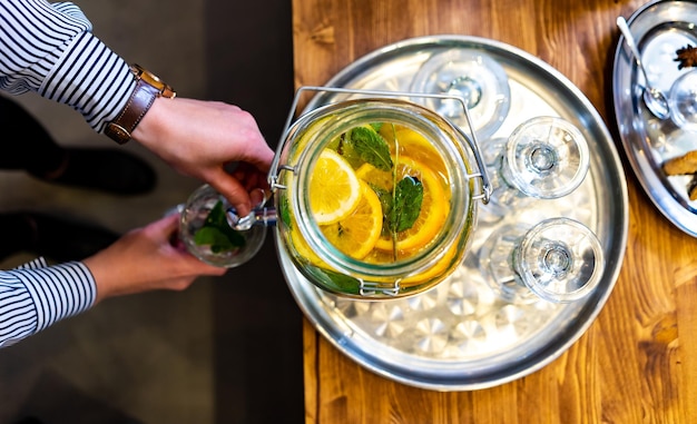 Mujer vertiendo limonada en un vaso