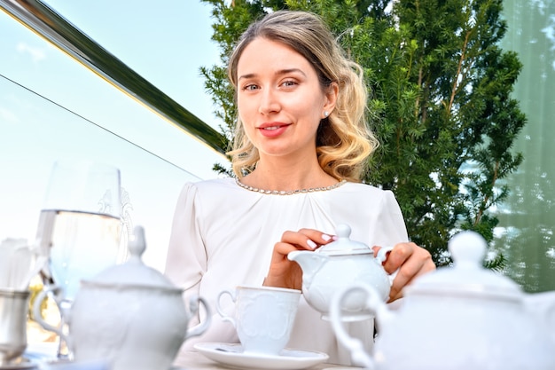Mujer vertiendo té o café en una taza