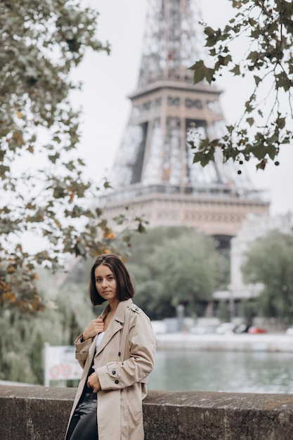 Mujer vestida con abrigo caminando por la famosa plaza con vistas a la Torre Eiffel