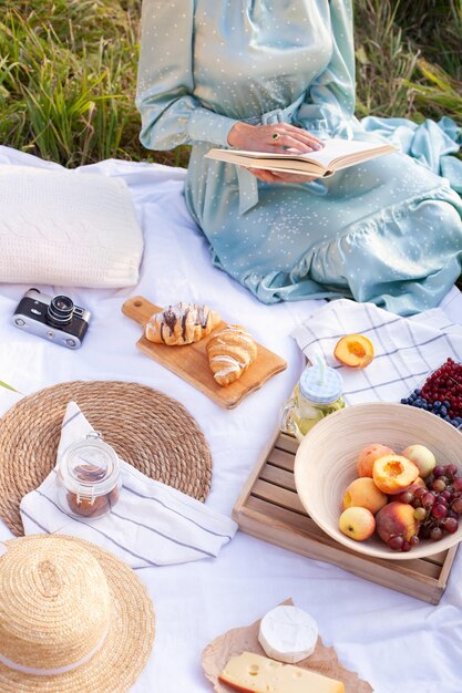 Una mujer vestida de azul se sienta en un picnic en un parque con vista panorámica