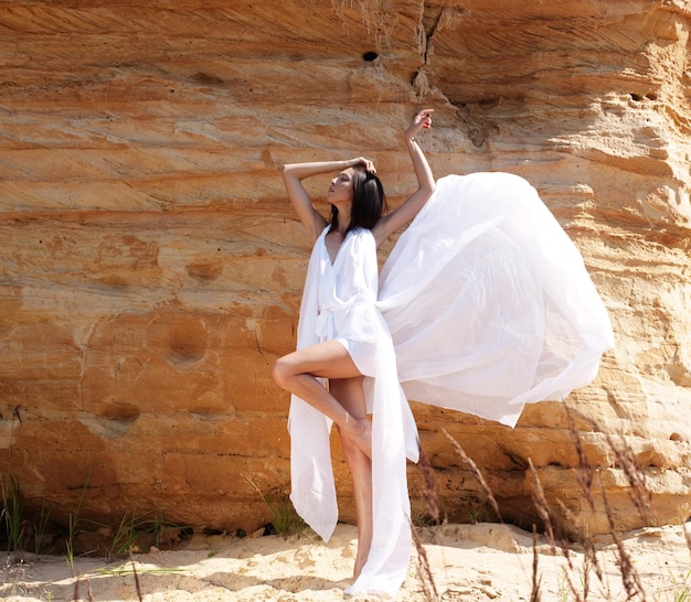 mujer vestida de blanco bailando en el desierto