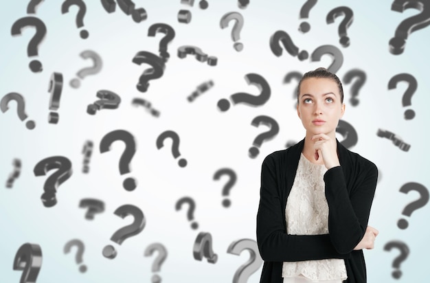 Mujer vestida de blanco y negro y signos de interrogación flotantes