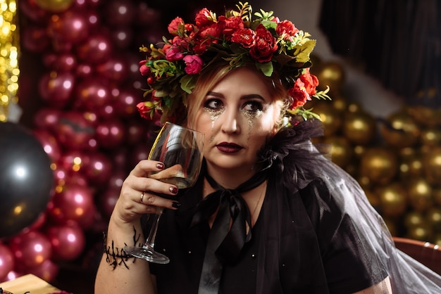 Mujer vestida de bruja con flores en la cabeza
