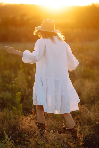 Foto mujer vestida a la moda al atardecer o al amanecer en la naturaleza de verano concepto de estilo de vida de glamour de moda