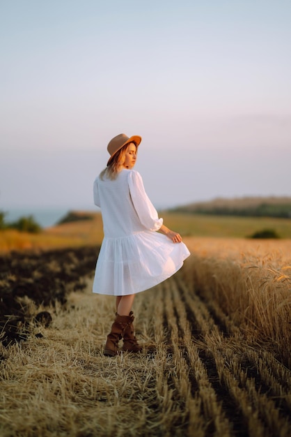 Mujer vestida a la moda al atardecer o al amanecer en la naturaleza de verano Concepto de estilo de vida de glamour de moda