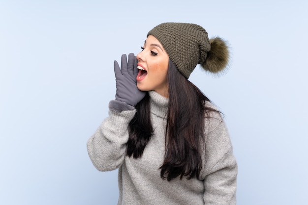 Mujer vestida con ropa de invierno sobre pared aislada