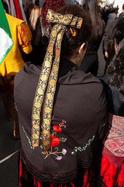 Una mujer vestida con el traje tradicional castellano con mantón y cintas en el pelo