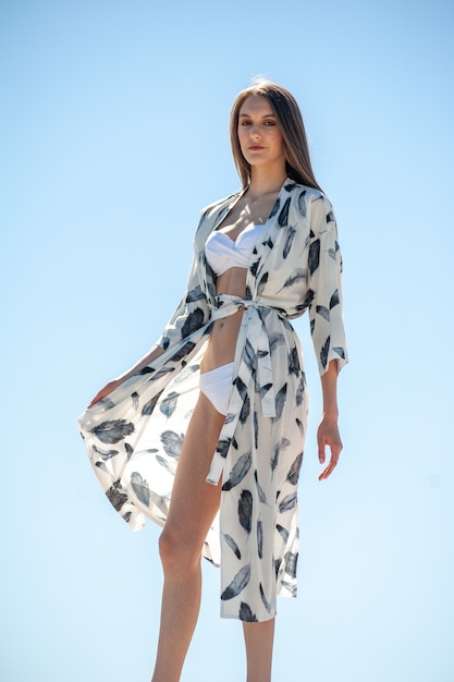 Mujer vestida con túnica de moda en la playa