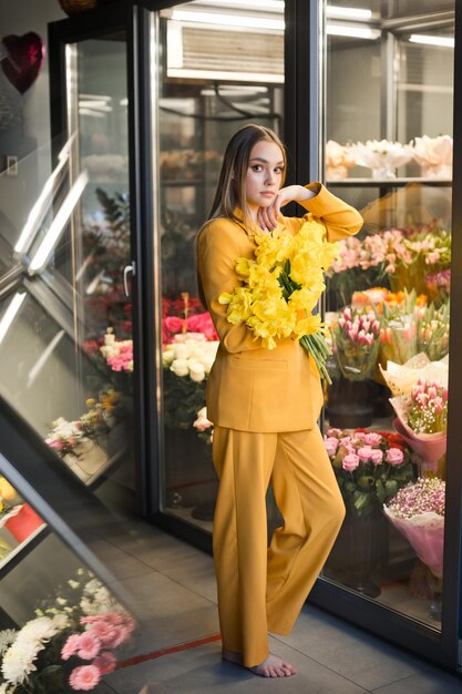 Foto una mujer con un vestido amarillo y con flores dentro de una tienda 4644