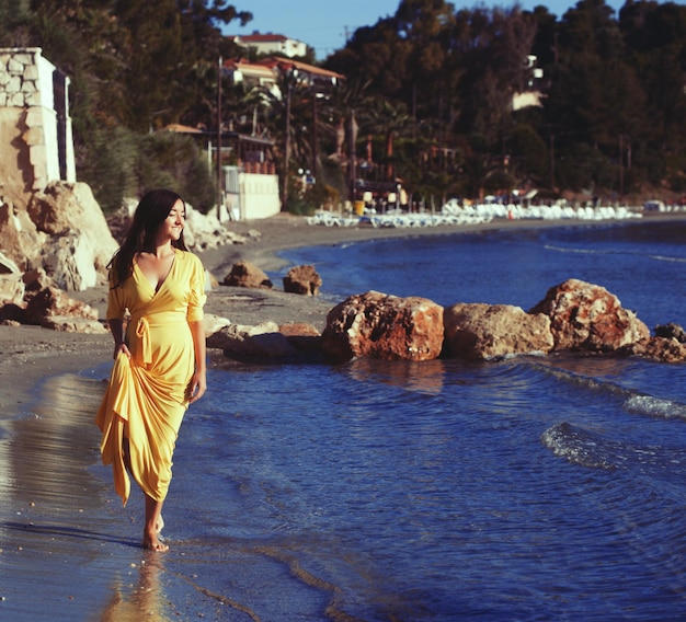 Mujer con vestido amarillo en una playa