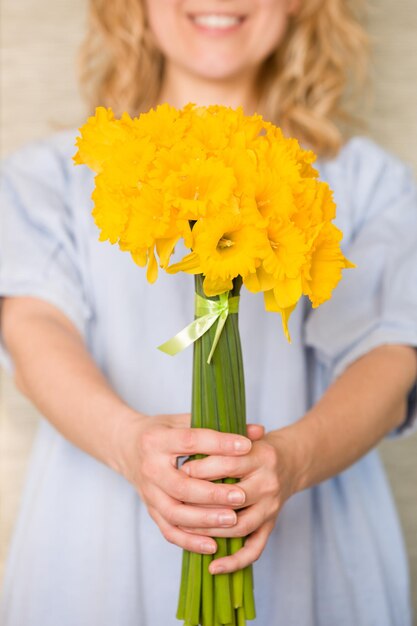 Mujer con vestido azul y hermoso ramo de flores en sus manos