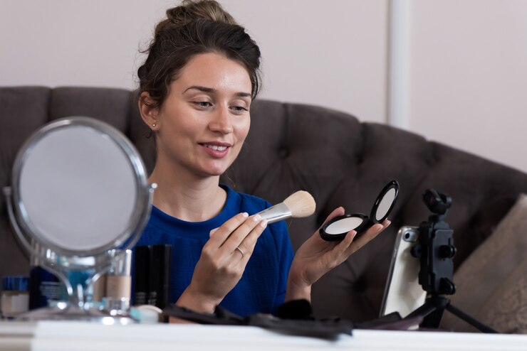 Foto mujer con vestido azul presentando un vlog de maquillaje