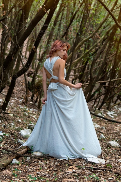 Una mujer con un vestido blanco en el bosque
