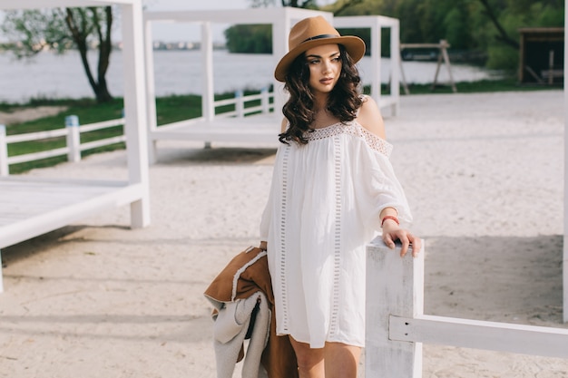 Mujer en vestido blanco cerca de la cerca