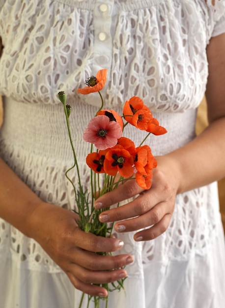 Mujer en vestido blanco con flores de amapola