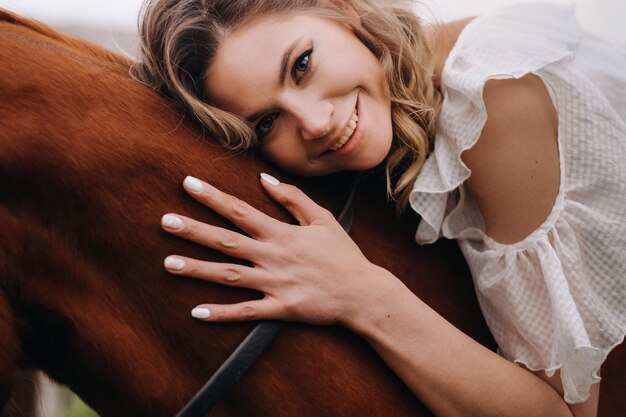 Una mujer con un vestido blanco montando un caballo cerca de una granja