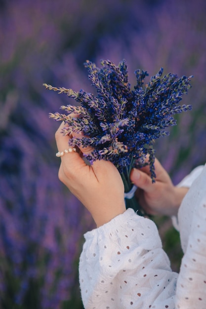 Mujer en vestido blanco con ramo de flores de lavanda cerrar