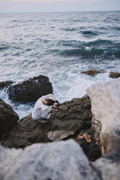 Mujer en vestido blanco rocas naturaleza paisaje océano viaje inalterado
