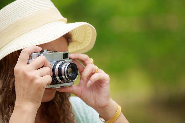 Mujer en vestido blanco tomando fotos de verde natural