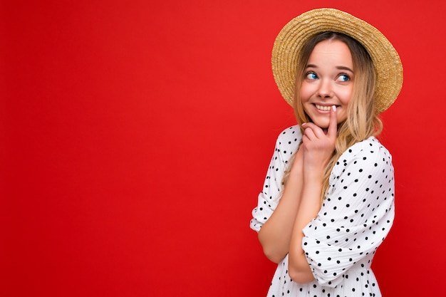 mujer en vestido casual de verano y sombrero de paja. Mujer positiva muestra emociones faciales.