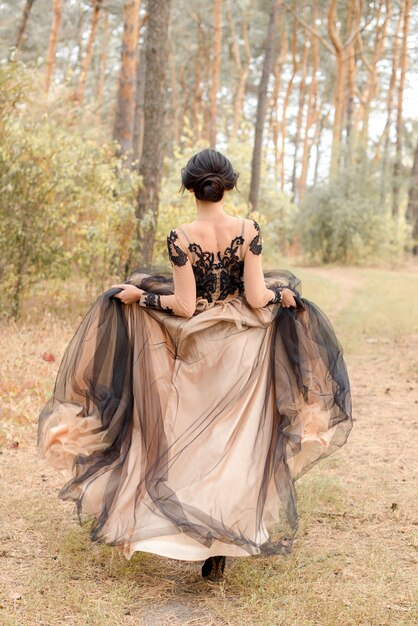 mujer en vestido corriendo en el bosque