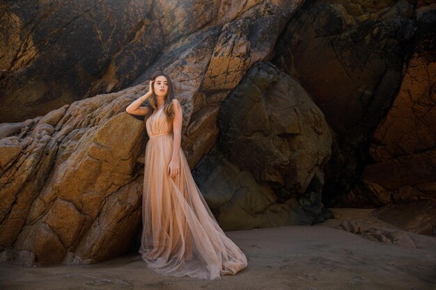 mujer, en, vestido largo, cerca, rocas, y, océano