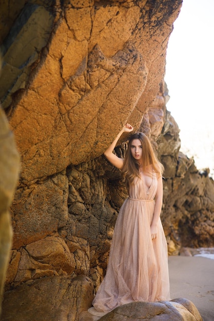 mujer, en, vestido largo, cerca, rocas, y, océano