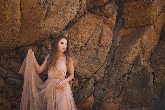 mujer, en, vestido largo, cerca, rocas, y, océano