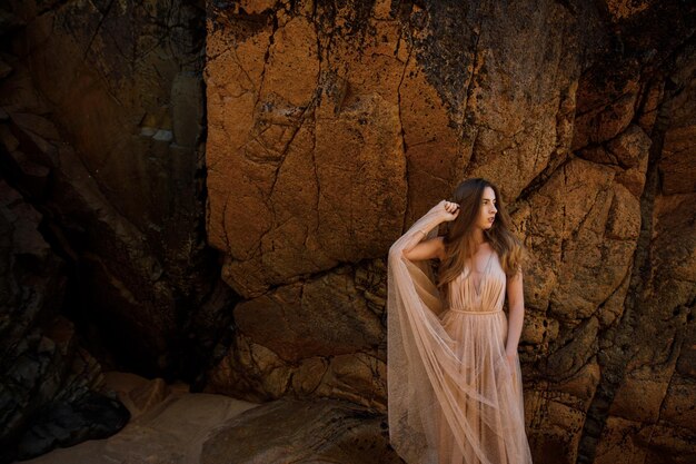 mujer, en, vestido largo, cerca, rocas, y, océano