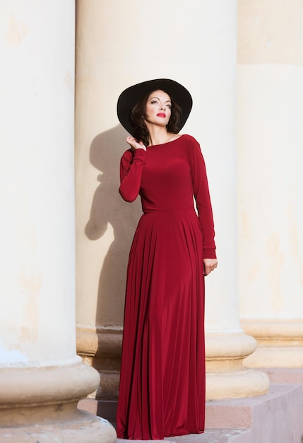 Mujer en el vestido largo rojo mirando hacia arriba