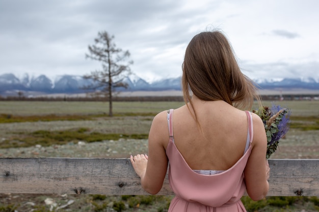 Una mujer con un vestido mira las montañas.