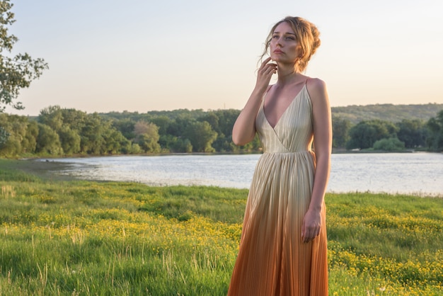 Mujer en vestido naranja al atardecer