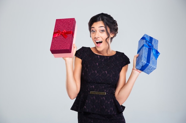 Mujer en vestido negro sosteniendo dos cajas de regalo