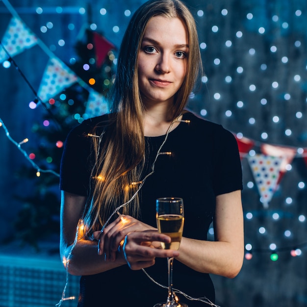 Mujer en vestido de noche con copa de vino espumoso Celebración año nuevo