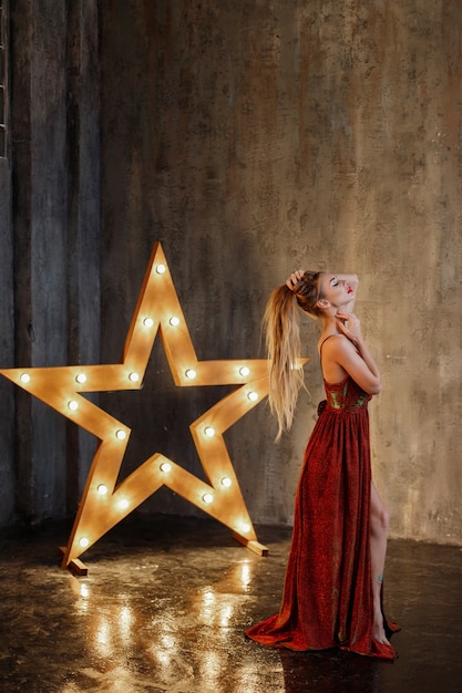 Mujer en vestido de noche rojo en una habitación oscura