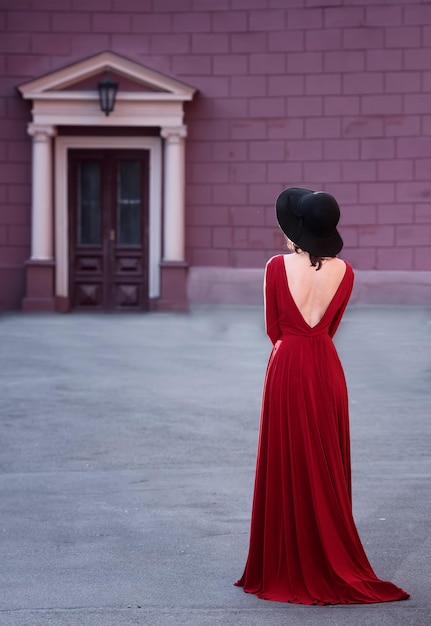 Mujer en vestido de noche rojo posando en la calle