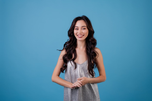 Mujer en vestido plateado aislado sobre azul