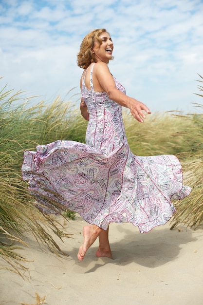 Mujer con vestido que fluye en la playa