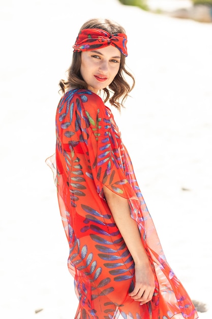 Una mujer con un vestido rojo con bufanda y diadema.