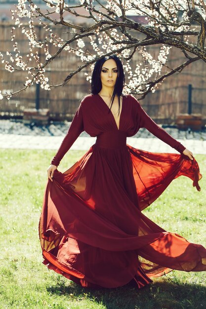 mujer, en, vestido rojo, cerca, flor