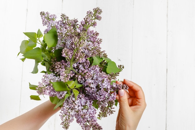 Mujer en vestido sosteniendo una gran rama de flor lila en su mano