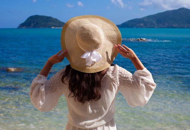 Mujer en vestido de verano con sombrero de paja