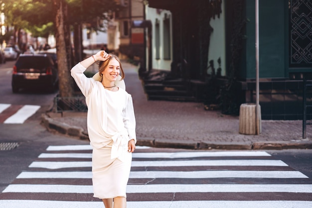 Mujer en vestido vintage blanco caminando en la calle