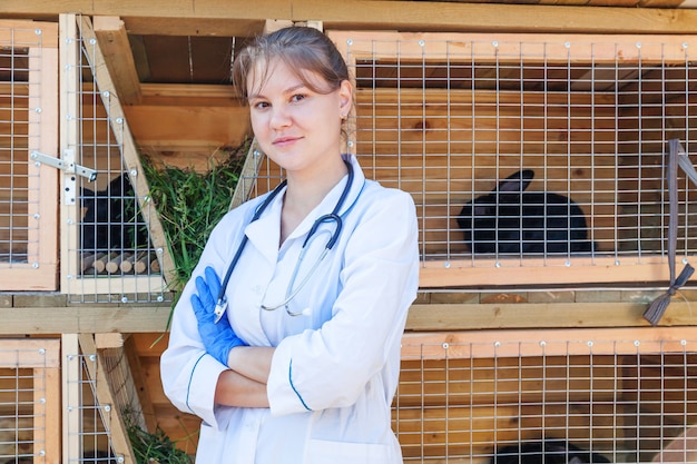 Mujer veterinaria con estetoscopio sobre fondo de rancho de granero