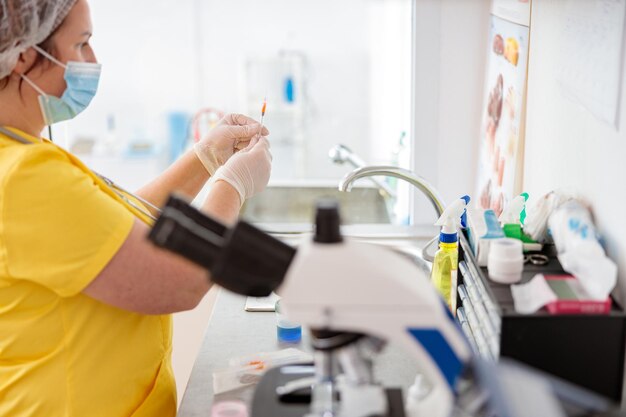 Mujer veterinario examina análisis de sangre en laboratorio