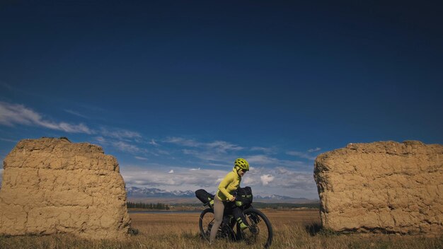 La mujer viaja en cicloturismo de terreno mixto con bikepacking. El viajero viaja con bolsas para bicicletas. Bikepacking de turismo deportivo.