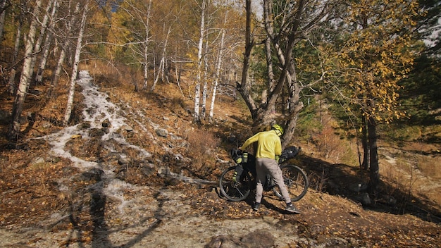 La mujer viaja en cicloturismo de terreno mixto con bikepacking